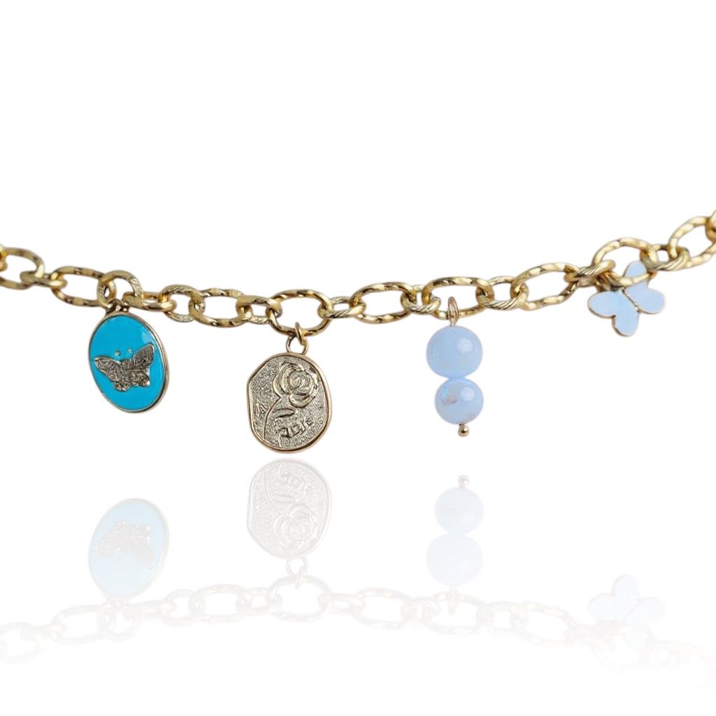 Bracelet doré avec breloque papillon bleu turquoise, médaillon rose, deux perles d’eau douce et papillon blanc – bijou artisanal assemblé à la main pour femme