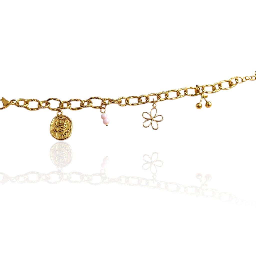 Bracelet Perlya doré avec médaillon rose, deux petites perles roses, fleur ajourée et breloque cerise